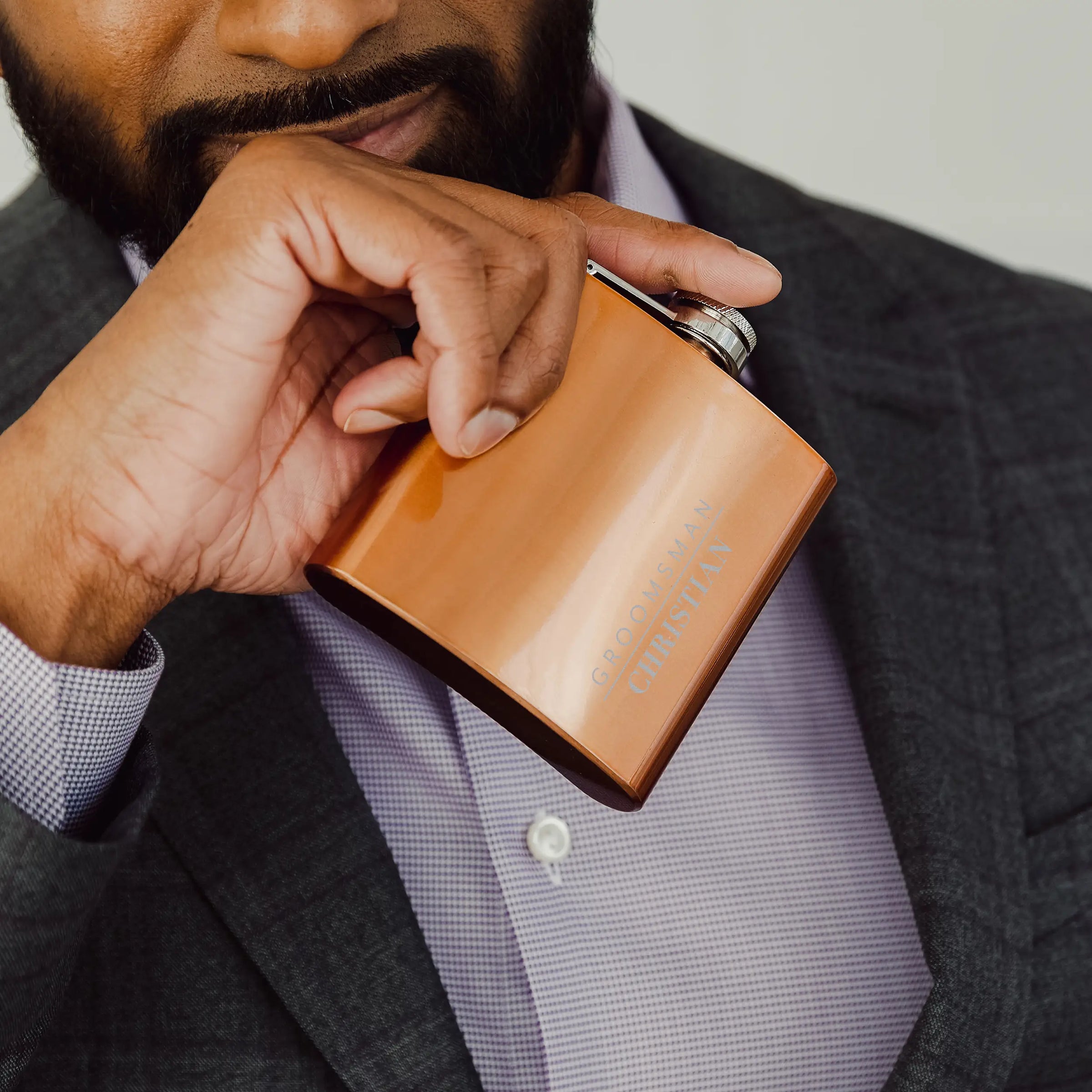 Person holding a copper flask with a blurred background